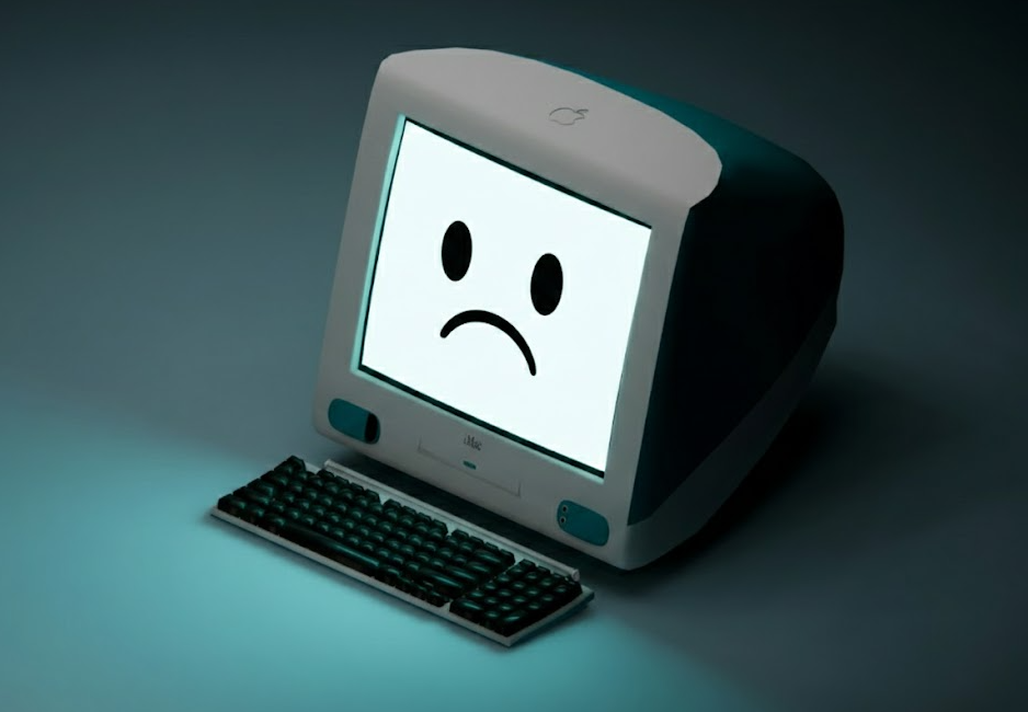 A vintage 1990s-style desktop computer in a dark room with a large, glowing sad face emoji on the screen.